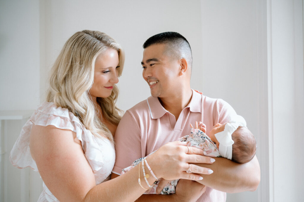Newborn baby girl swaddled in cream with bow captured by Lexington newborn photographer
