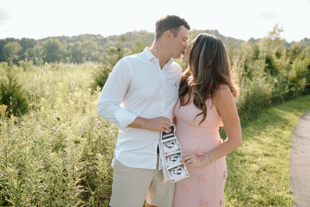 Pregnant couple smiling during pregnancy announcement photoshoot in Louisville KY