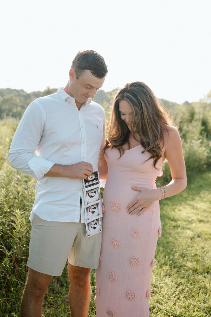 Pregnant couple smiling during pregnancy announcement photoshoot in Louisville KY