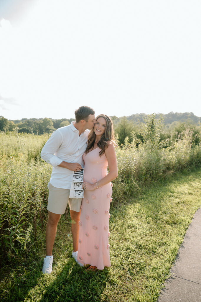 Pregnant couple smiling during pregnancy announcement photoshoot in Louisville KY