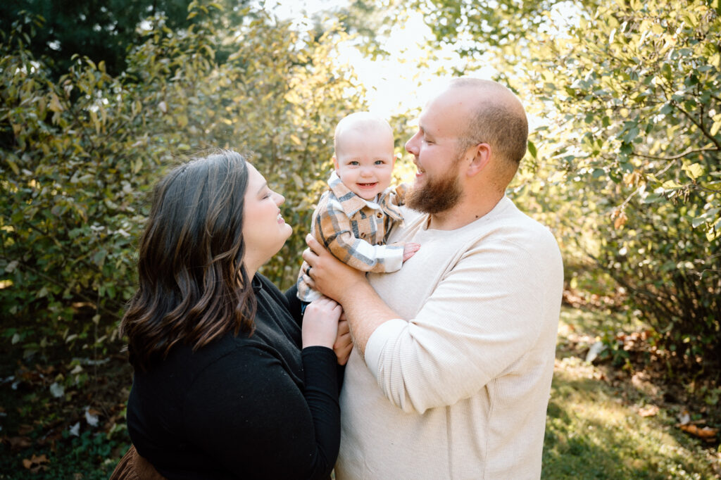 Family in cozy fall outfits posing among colorful autumn leaves]
Family enjoying fall photo session outdoors with colorful autumn leaves in Lexington


