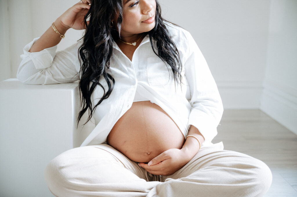 Expecting parents walking hand in hand with toddler in outdoor maternity photoshoot.