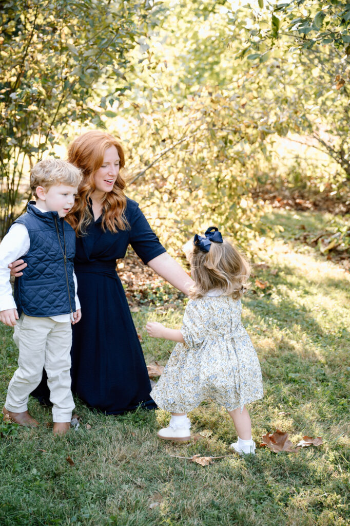 Parent and child walking on a leaf-covered path during fall mini session in Lexington