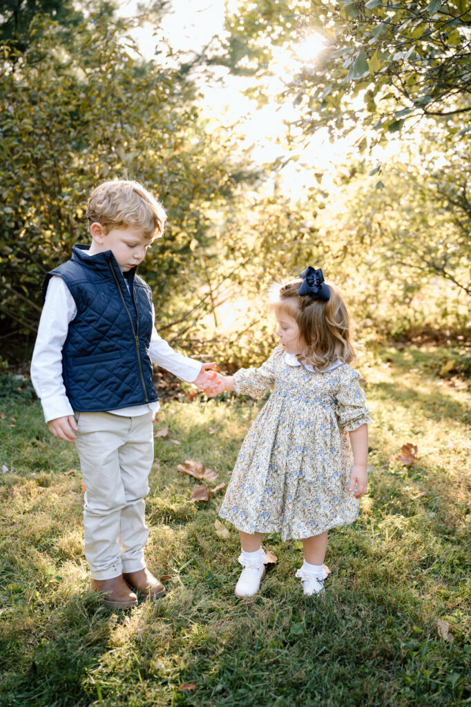 Parent and child walking on a leaf-covered path during fall mini session in Lexington