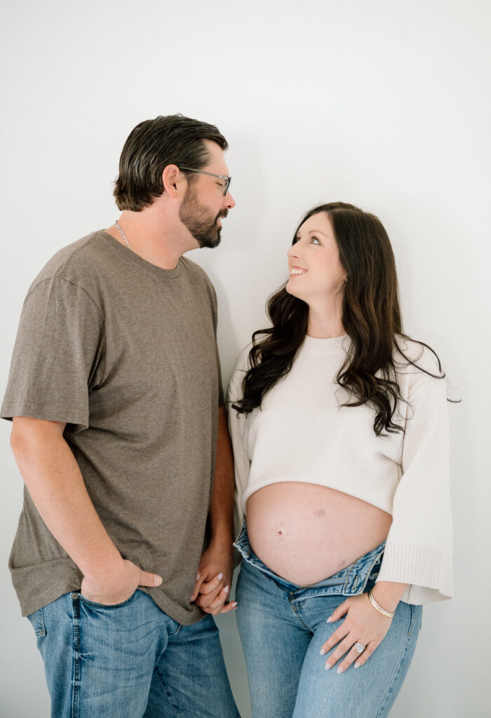 Close-up maternity photo of expecting mom’s hands on baby bump in Lexington studio