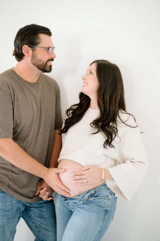 Close-up maternity photo of expecting mom’s hands on baby bump in Lexington studio