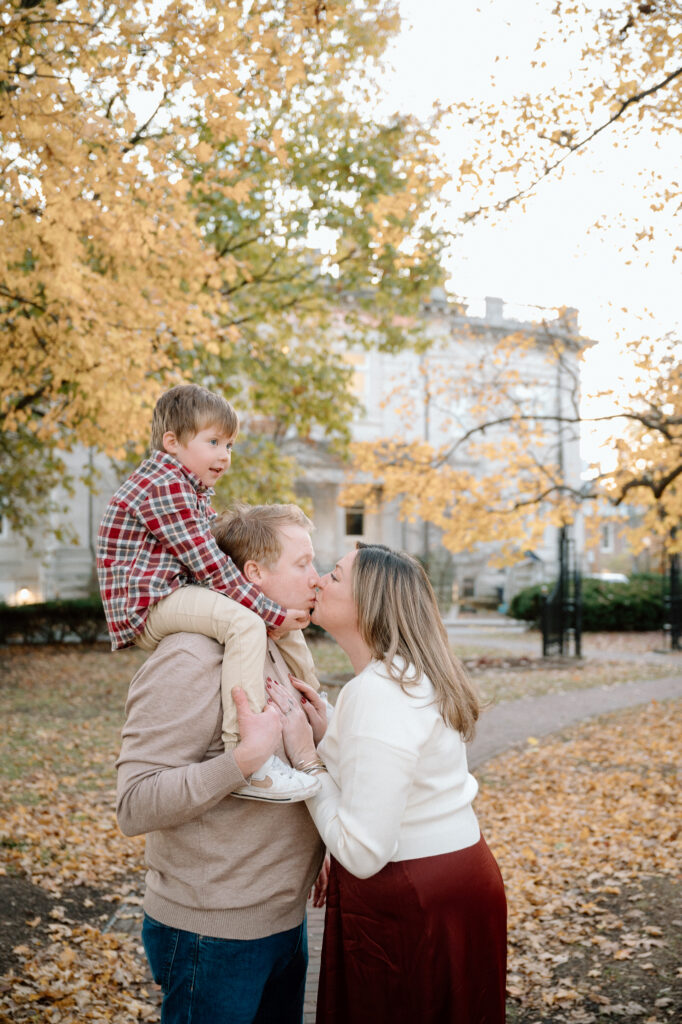 Golden fall foliage behind a family during a Lexington fall mini session at Gratz Park in 2025.