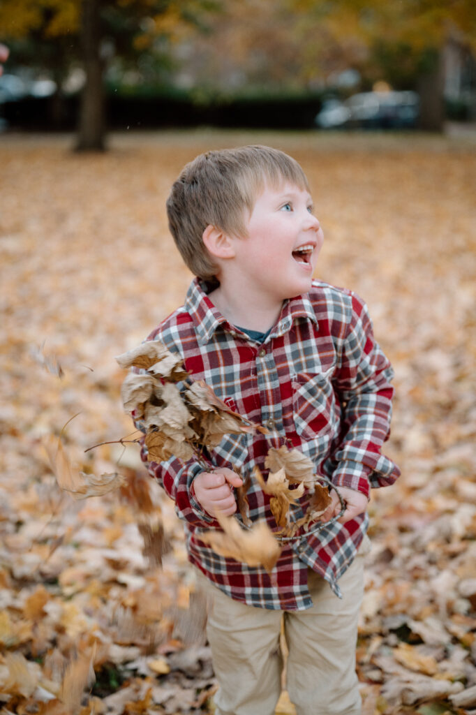 Golden fall foliage behind a family during a Lexington fall mini session at Gratz Park in 2025.