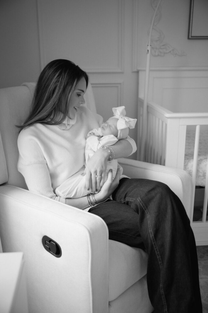 Photographer capturing candid moment of new parents with their newborn in their Louisville home.