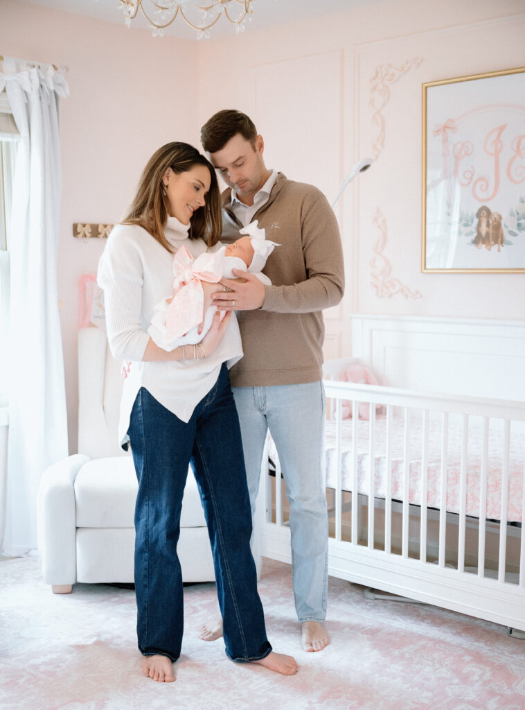 Louisville newborn lifestyle session with parents holding baby in natural window light.