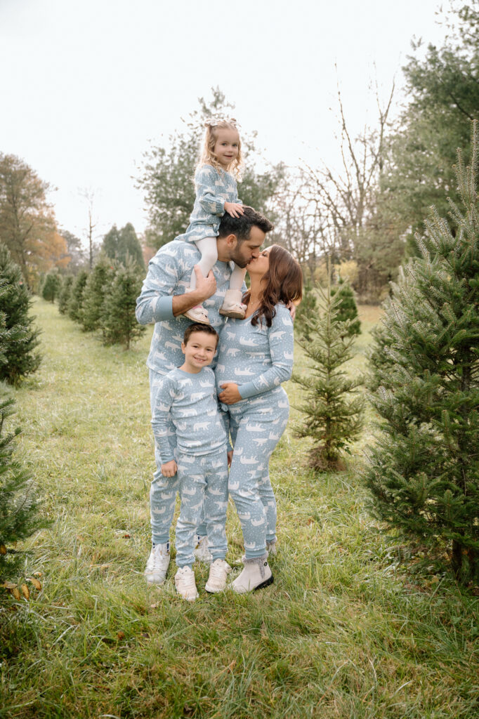family standing in Christmas tree farm during holiday mini session in Kentucky