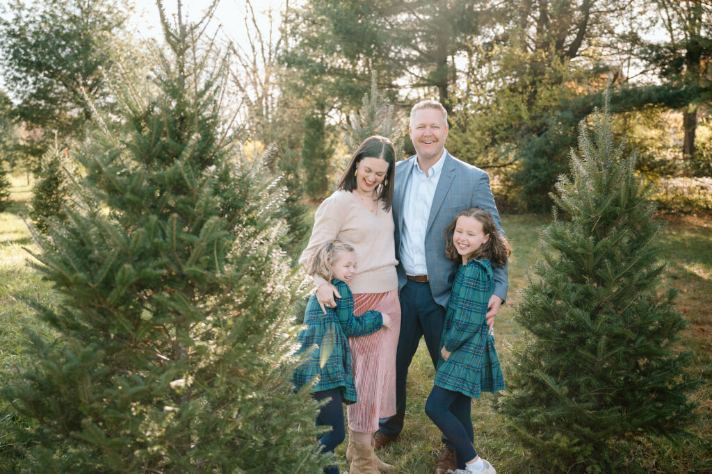 family standing in Christmas tree farm during holiday mini session in Kentucky