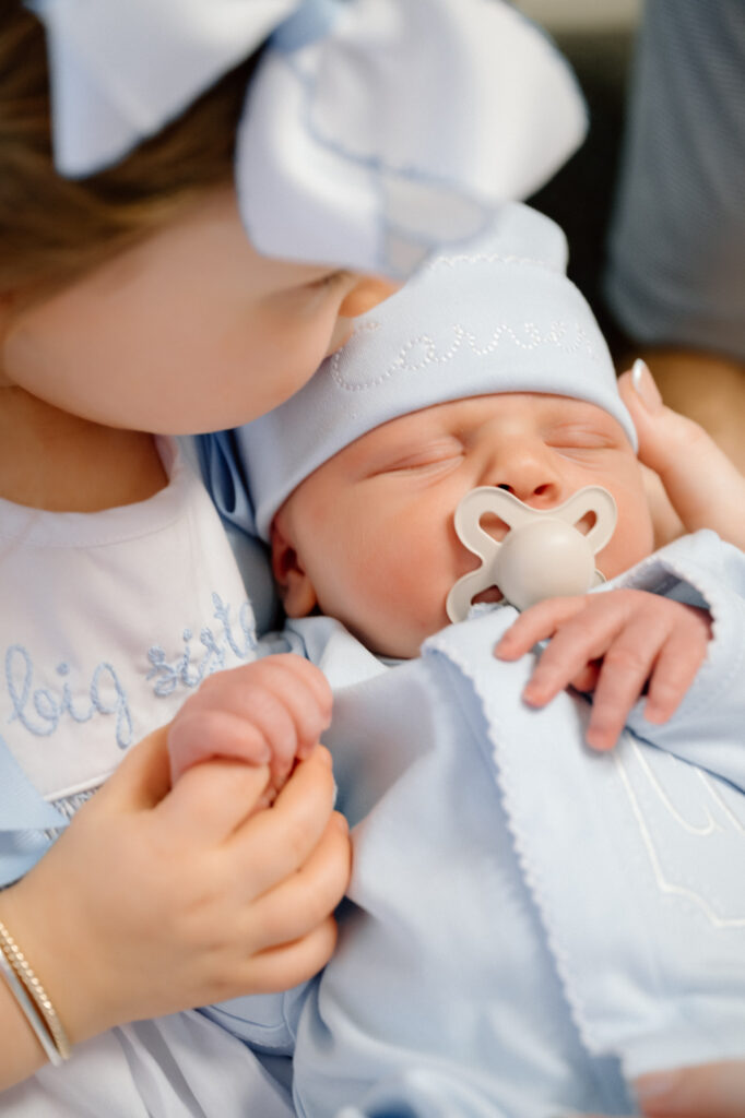 big sister snuggling newborn brother during fresh 48 session in Louisville hospital