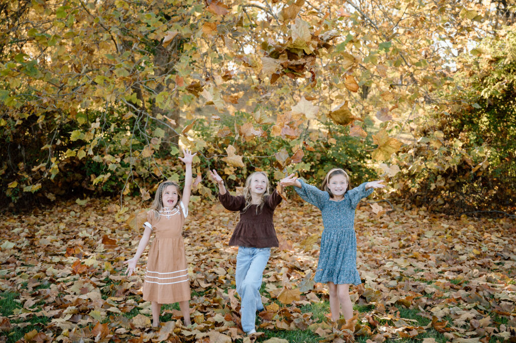 Toddler playing in a pile of leaves during Kentucky fall minis 2025 at Keeneland
